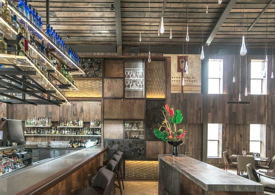 Sophisticated cocktail bar with dark wood paneling and hanging glass racks.