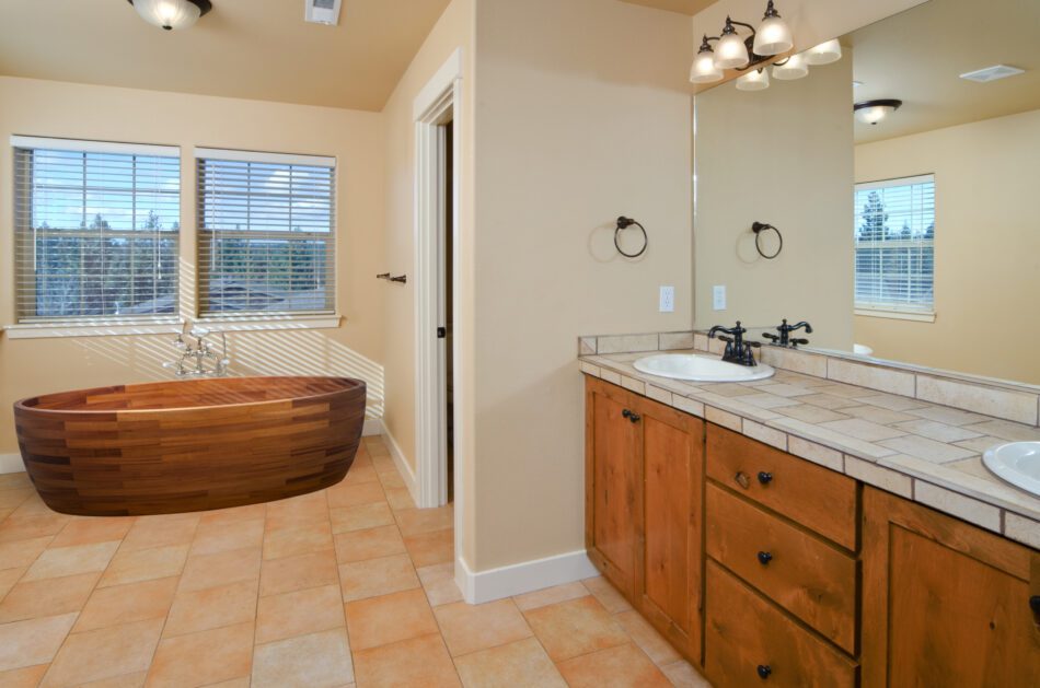Spacious bathroom with wood soaking tub and double sink vanity.